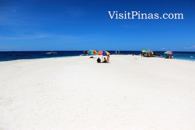 Umbrellas add shade and color in pure White Island, Camiguin